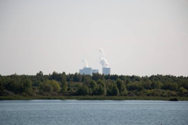LEIPZIG, ALMANY - 19 AĞUSTOS 2018: Markkleeberger 'e bakın ufukta uzak bir enerji santrali ve ön planda sakin bir su var. Yüksek kalite fotoğraf