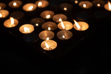  Birçok titreyen çay mumları karanlık ve huzurlu ortamda yanar. Yüksek kalite fotoğraf