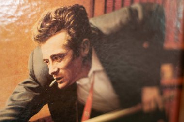 MÜZİK, GERMANY - 17 HAZİRAN 2018: Çerçevelenmiş duvar sanatı, Amerikalı aktör James Dean 'in dramatik bir şekilde sigarayla öne eğilmiş, Münih' te kapalı alanda sıcak ışıklandırmayla sergilenmiş,