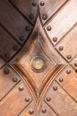 Yakın plan dekoratif perçinli ahşap kapı elmas şekilli metal süs ve merkezi düğmeli. Yüksek kalite fotoğraf