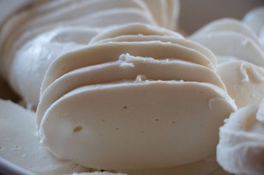 ChatGPT der ki: Dilimlenmiş mozzarella peynirinin pürüzsüz dokuya ve kremsi beyaz renge yakın çekimi. Yüksek kalite fotoğraf