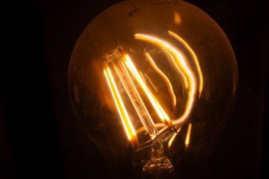  Ilık bir filamanla parıldayan Edison ampulünün yakın çekimi. Yüksek kalite fotoğraf