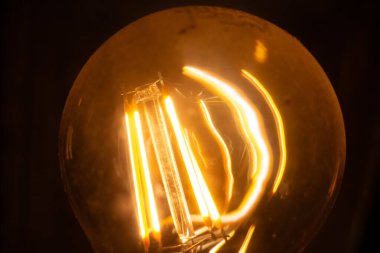  Ilık bir filamanla parıldayan Edison ampulünün yakın çekimi. Yüksek kalite fotoğraf