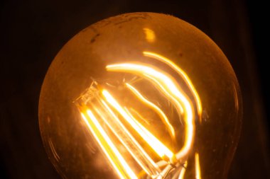  Ilık bir filamanla parıldayan Edison ampulünün yakın çekimi. Yüksek kalite fotoğraf