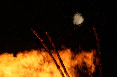  Büyük, parlak bir şenlik ateşi ve gece enerjisiyle uzak bir ay. Yüksek kalite fotoğraf