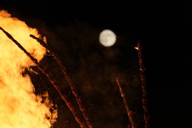  Büyük, parlak bir şenlik ateşi ve gece enerjisiyle uzak bir ay. Yüksek kalite fotoğraf