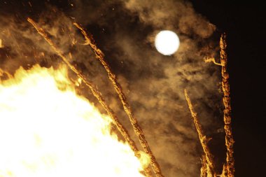  Büyük, parlak bir şenlik ateşi ve gece enerjisiyle uzak bir ay. Yüksek kalite fotoğraf