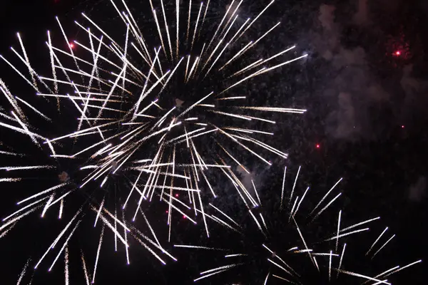  Karanlık bir gökyüzü kutlaması ve aydınlıkta renkli havai fişekler patlıyor. Yüksek kalite fotoğraf