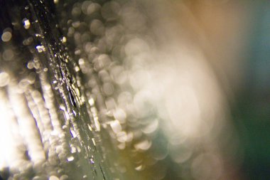  Karanlık bir yüzeye düşen bulanık yağmur damlalarının soyut arkaplanı. Yüksek kalite fotoğraf