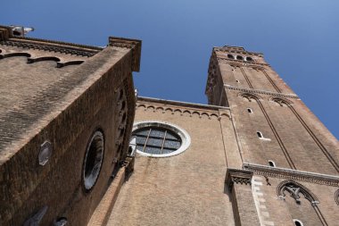VENICE, İtalya - 24 AĞUSTOS 2013: Açık mavi gökyüzüne karşı Basilica dei Fraris ikiz tuğla kuleleri ve gotik cephe manzarası. Yüksek kalite fotoğraf