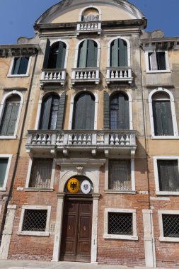 VENICE, İtalya - 24 AĞUSTOS 2013: Açık mavi gökyüzü altında kemerli pencereleri ve dekoratif balkonu olan tarihi Venedik sarayı. Yüksek kalite fotoğraf