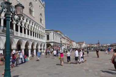 VENICE, İtalya - 24 AĞUSTOS 2013: Turistler güneşli bir yaz gününde Doges Sarayı yakınlarındaki gezinti alanı boyunca yürürler. Yüksek kalite fotoğraf