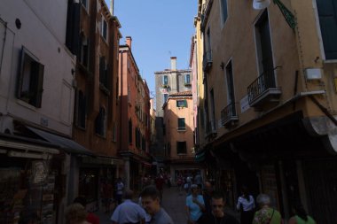 Venedik, İtalya - 24 Ağustos 2013: Venedik 'in merkezindeki eski binalar arasındaki dar yaya caddelerinde yürüyen turistler. Yüksek kalite fotoğraf