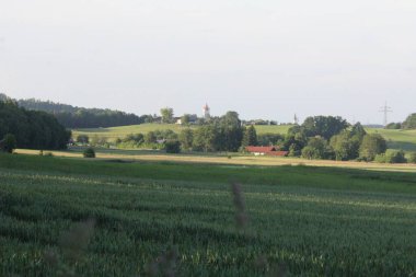 RECHTMEHRING, ALMANY - 31 Mayıs 2025: Ufukta Schlossturm ve kilise kulesi ile birlikte Oberbayern 'deki Haag' a doğru Rechtmehring 'den uzak görüş. Yüksek kalite fotoğraf