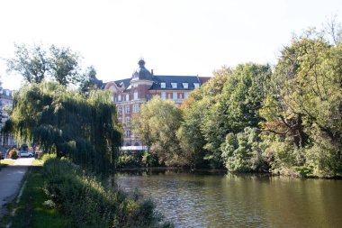 COPENHAGEN, DENMARK - 21 Eylül 2017: Kopenhag 'ın merkezinde açık mavi bir gökyüzü altında yeşil ağaçlar tarafından kısmen gizlenmiş kubbeli ve süslü çatı mimarisi tarihi bina. Yüksek kalite fotoğraf