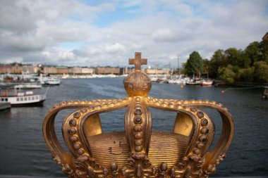 STOCKHOLM, SWEDEN - 19 Eylül 2017: Skeppsholmsbron Köprüsü 'nde Stockholm Limanı' nın bulanık arka planında altın taç süsü. Yüksek kalite fotoğraf