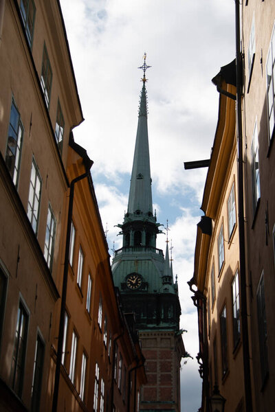STOCKHOLM, SWEDEN - SEPTEMBER 19, 2017: The spire of the German Church or Tyska kyrkan framed by buildings in Gamla Stan. High quality photo