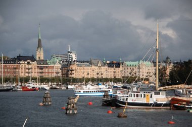 STOCKHOLM, SWEDEN - 19 Eylül 2017: Stokholm limanı botlarla ve bulutlu bir gökyüzü altında şehrin ufuk çizgisi. Yüksek kalite fotoğraf
