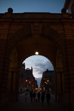 STOCKHOLM, SWEDEN - 19 Eylül 2017: Stockholm 'de alacakaranlıkta loş bir şehir caddesini insanlarla donatan tarihi taş kemer. Yüksek kalite fotoğraf