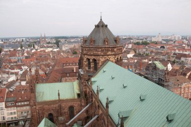 STRASBOURG, FRANCE - 27 AĞUSTOS 2017: Strasbourg Katedrali 'nden yeşil bakır çatıları ve eski şehrin arka planına karşı kuleyi gösteren görüntü. Yüksek kalite fotoğraf