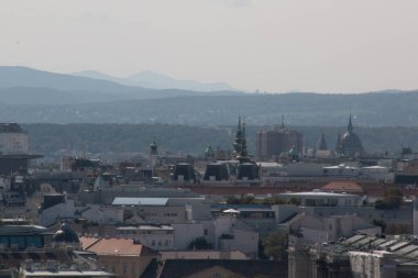 Viyana, AUSTRIA - 9 Eylül 2017 Viyana 'nın sayısız çatısı, tarihi kulesi ve uzak puslu tepeleri olan panoramik manzarası. Yüksek kalite fotoğraf