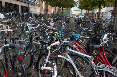 COPENHAGEN, DENMARK - 21 Eylül 2017: Kopenhag 'ın orta kesimindeki bir cadde boyunca park halindeki bisikletlerden oluşan yoğun küme güçlü bisiklet kültürünü yansıtıyor. Yüksek kalite fotoğraf