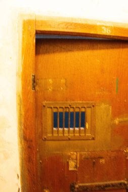 Dachau, Almanya - 25 Kasım 2017: Dachau toplama kampı anıtı içinde küçük parmaklıklı pencereli ahşap hapishane kapısı. Yüksek kalite fotoğraf