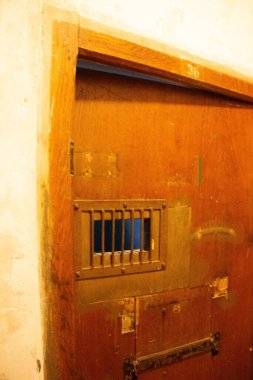 Dachau, Almanya - 25 Kasım 2017: Dachau toplama kampı anıtı içinde küçük parmaklıklı pencereli ahşap hapishane kapısı. Yüksek kalite fotoğraf