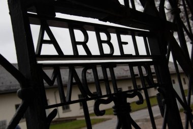 DACHAU, GERMANY - 25 Kasım 2017: Dachau toplama kampı anıtı girişinde Arbeit macht frei yazısıyla tarihi demir kapıdan bakın. Yüksek kalite fotoğraf
