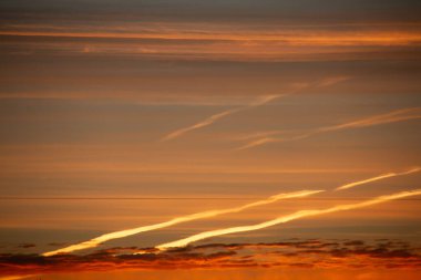 Gün batımında sıcak ve serin tonlarla çapraz uçan uçak gökyüzünde zıtlaşıyor. Yüksek kalite fotoğraf