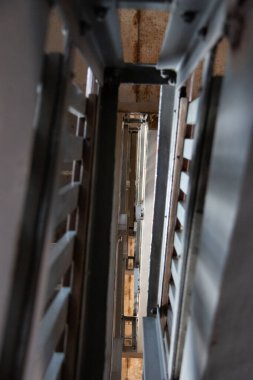 Modern metal korkuluklar ile geometrik simetri ve endüstriyel aydınlatma arasındaki dikey merdiven boşluğuna bakıyorum. Yüksek kalite fotoğraf