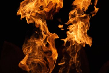 İzole olmuş alevler, dinamik ateş şekilleriyle siyah zemin üzerinde yükseliyor. Yüksek kalite fotoğraf