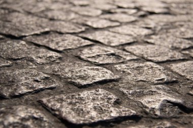 Yıpranmış kaldırım taşı yüzeyinin dokulu yüzeyinin alçak açılı görüntüsü. Yüksek kalite fotoğraf