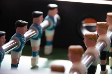Odaklanmış metal çubuklu plastik oyuncuların olduğu bir masa futbolu maçının yakın görüntüsü. Yüksek kalite fotoğraf