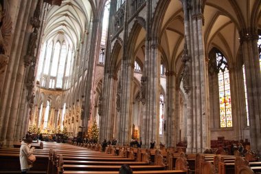 COLOGNE, Almanya - 29 Aralık 2017: Yükselen gotik kemerleri, vitray pencereleri ve ahşap sıraları olan Köln Katedrali 'nin geniş açılı iç manzarası. Yüksek kalite fotoğraf