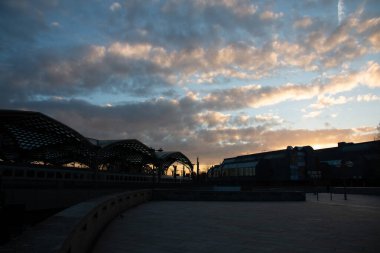 COLOGNE, GERMANY - 29 Aralık 2017: Hohenzollern Köprüsü ve Köln Merkez İstasyonu üzerinde gün doğumu dramatik bulutlar ve Ren Nehri 'ne yansıyan erken ışık. Yüksek kalite fotoğraf