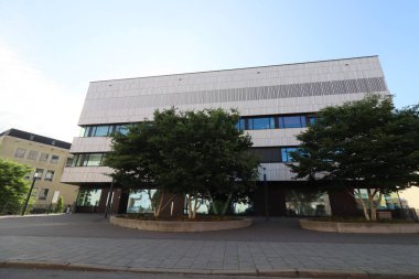 MUNİH, GERMANY - 24 Haziran 2025: Simetrik ağaçlar ve sabah ışığında asfalt avlu ile modern üniversite binası cephesi. Yüksek kalite fotoğraf