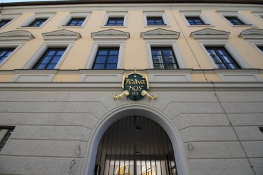 MUNICH, GERMANY - 24 Haziran 2025: Maxvorstadt bölgesinde kemerli kapısı ve neoklasik mimarisi olan Kinder binasının ön cephesi ve ana girişi. Yüksek kalite fotoğraf