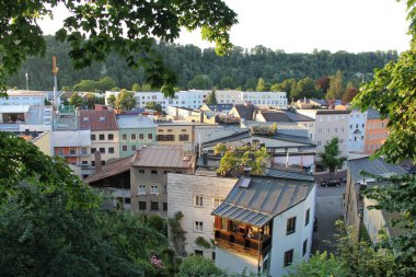 WASSERBURG AM Hanı, GERMANY - 20 Haziran 2025: Wasserburg am Inn 'in çatıları üzerinde ağaçlar tarafından çerçevelenmiş yerleşim ve tarihi binalar. Yüksek kalite fotoğraf