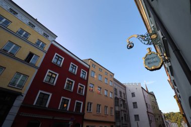 WASSERBURG AM Hanı, GERMANY - 20 Haziran 2025: Wasserburg am Inn 'in tarihi merkezinde renkli bir caddede asılı geleneksel dövmeli demir bira fabrikası tabelası. Yüksek kalite fotoğraf