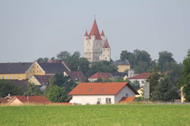 HAAG OBERBAYERN, GERMANY - 19 Haziran 2025: Haag Kalesi 'nin renkli köy evleri ve Yukarı Bavyera' daki yeşil alanlar üzerinde yükselen kırmızı noktalı manzarası. Yüksek kalite fotoğraf