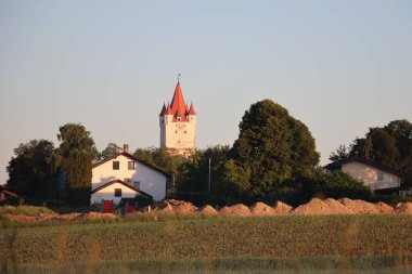 HAAG OBERBAYERN, GERMANY - 31 Mayıs 2025: Ortaçağ Schlossturm kulesinin manzarası ve Haag yakınlarındaki ağaçlar ve tarlalarla çevrili beyaz bir yerleşim yeri