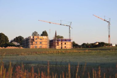 HAAG in OBERBAYERN, ALMANY - 31 Mayıs 2025: Lerchenberg, Haag 'daki bir yerleşim alanının inşaatı sabahın erken saatlerinde vinçleri ve iskelesi ile birlikte. Yüksek kalite fotoğraf
