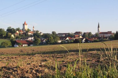 HAAG OBERBAYERN, ALMANY - 31 Mayıs 2025: Sabah erken saatlerde Haag Kalesi ve Mariae Himmelfahrt Kilisesi ön planda tarlaları sürülmüş. Yüksek kalite fotoğraf