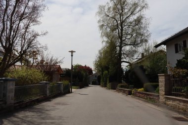 HAAG, ALMANY - 20 Nisan 2025: Oberbayern, Haag 'daki Alpenstrasse' nin sakin manzarası bir bahar günü konut evleri, ağaçlar ve sokak lambalarıyla. Yüksek kalite fotoğraf