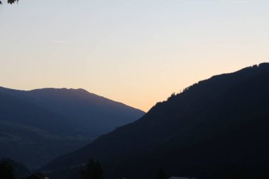 Gün batımında Tirol Avusturya 'da dağ siluetleri ve orman yamaçları. Yüksek kalite fotoğraf