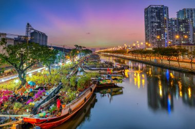 Ho Chi Minh City, Vietnam - 31 Ocak 2022 Kanal iskelesi boyunca pazarda çiçek teknesi. Çiftçiler, Ho Chi Minh, Vietnam 'daki Ay Yeni Yılı' nda kayısı çiçeği ve diğer çiçekleri satıyor.