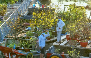 Ho Chi Minh Şehri, Vietnam - 31 Ocak 2022: Çiçek pazarından çiçek satın alma telaşı, yerel halk dekorasyon amacıyla çiçek satın alıyor..