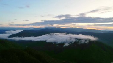 Da Lat, Vietnam 'daki mistik dağların üzerinden bulutların üzerinde renkli bir güneş doğuyor. Zaman akıp gidiyor.