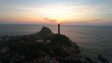 Güneşin doğuşunda antik deniz feneriyle küçük bir adanın manzarası güzel ve huzurludur. Bu sadece Vietnam 'daki bir adada bulunan eski bir deniz feneri.